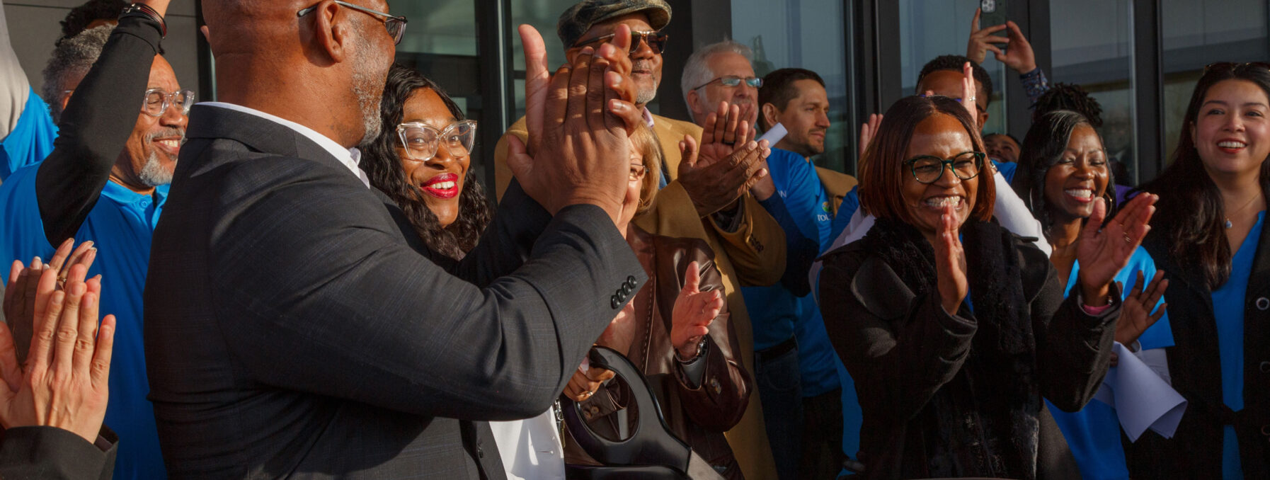 Group of people outside Tolson Center actively cutting the ribbon to symbolize the grand opening.