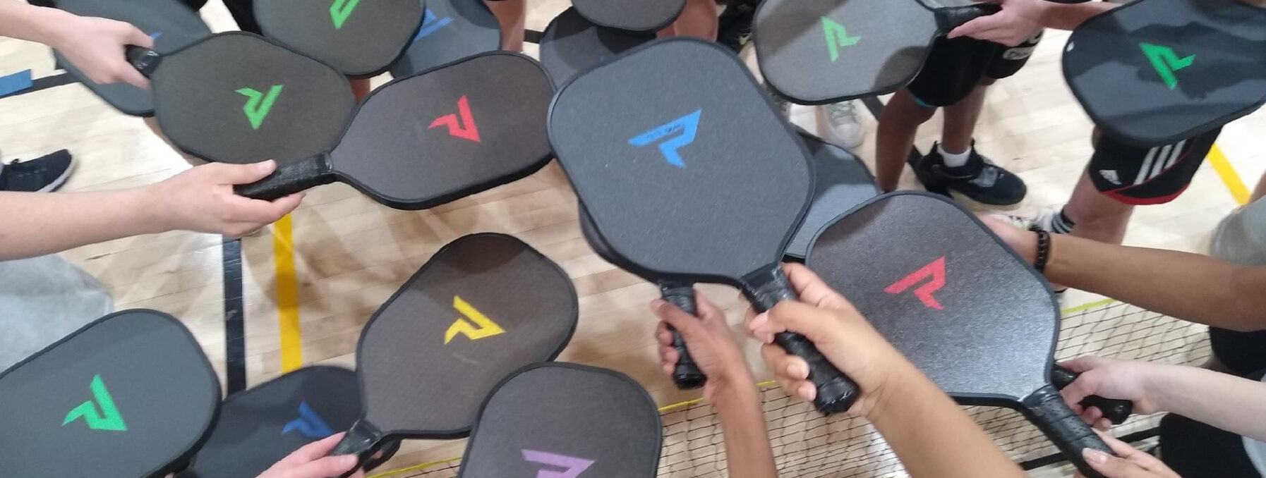 Pickleball paddles held in a circle.